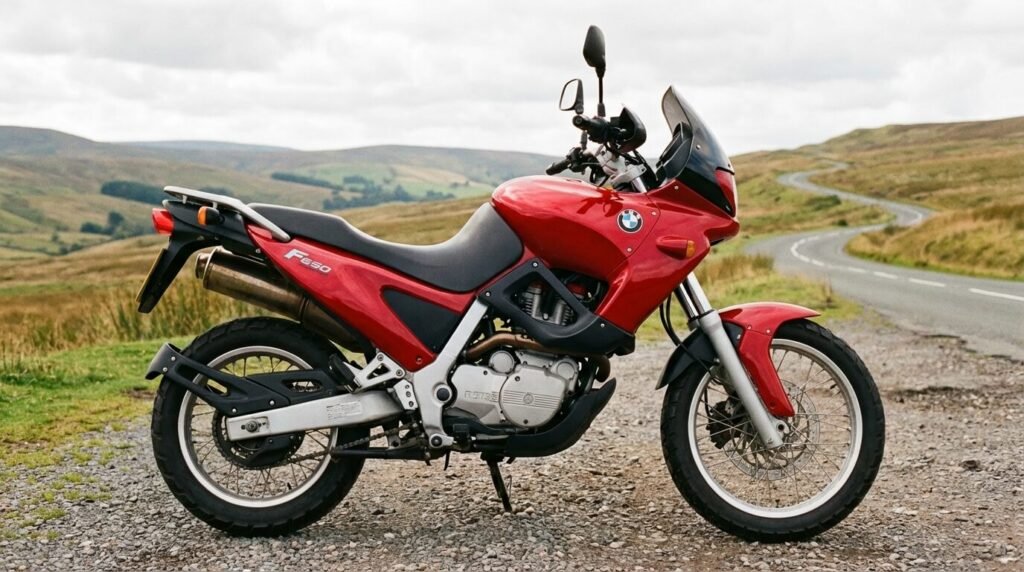 Profil d'une BMW F650 Funduro rouge des années 90, montrant son architecture typique de trail routier monocylindre