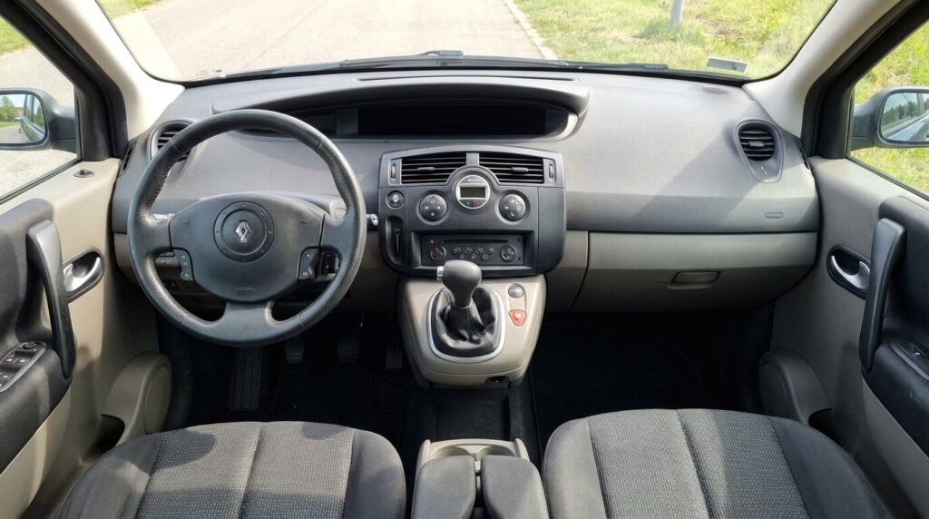 Intérieur de Renault Scénic 2 avec le tableau de bord numérique central totalement éteint (écran noir), panne typique de ce modèle familial