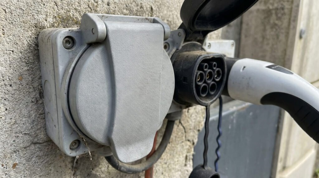 Gros plan sur une prise Type 2S (avec obturateur/clapet de sécurité) conforme à la norme française, montrant la différence physique avec le connecteur Tesla standard