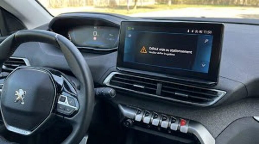 L'écran central d'une Peugeot affichant le message d'alerte Défaut aide au stationnement.