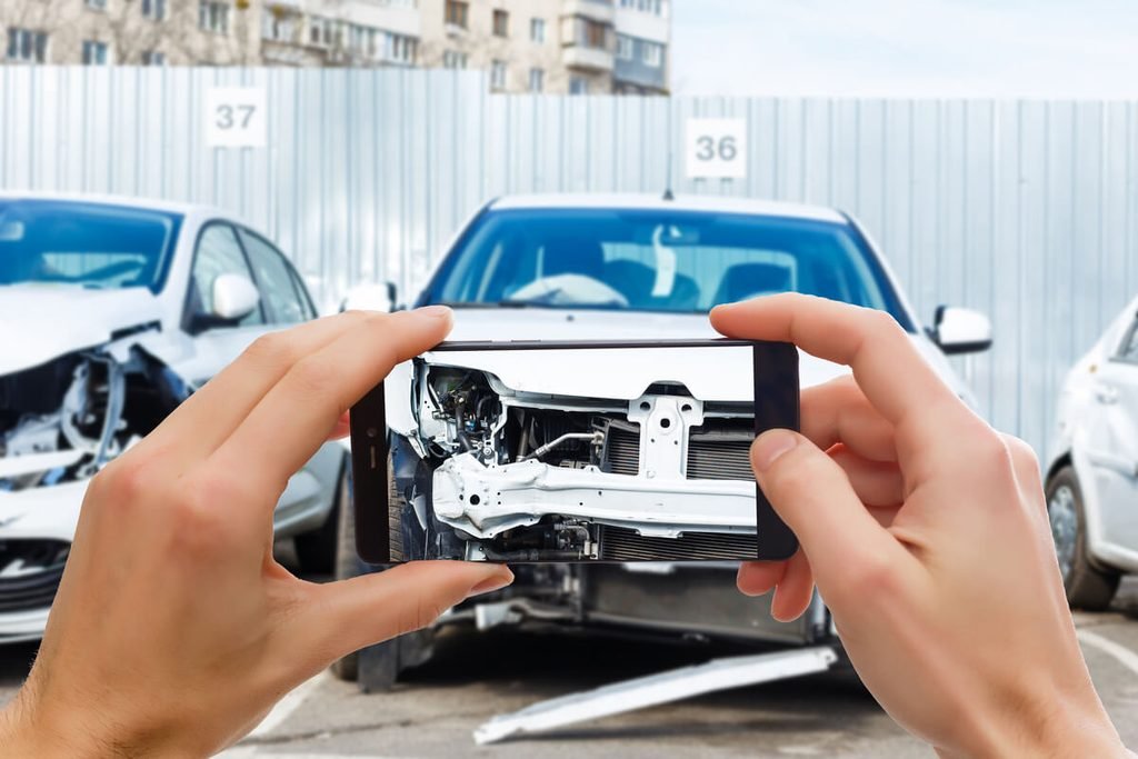 Expert automobile évaluant les dommages de carrosserie sur un véhicule sous contrat de location avec option d'achat.