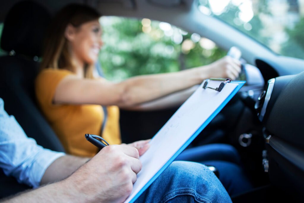 Moniteur d'auto-école conseillant un candidat au volant lors d'une leçon de perfectionnement.