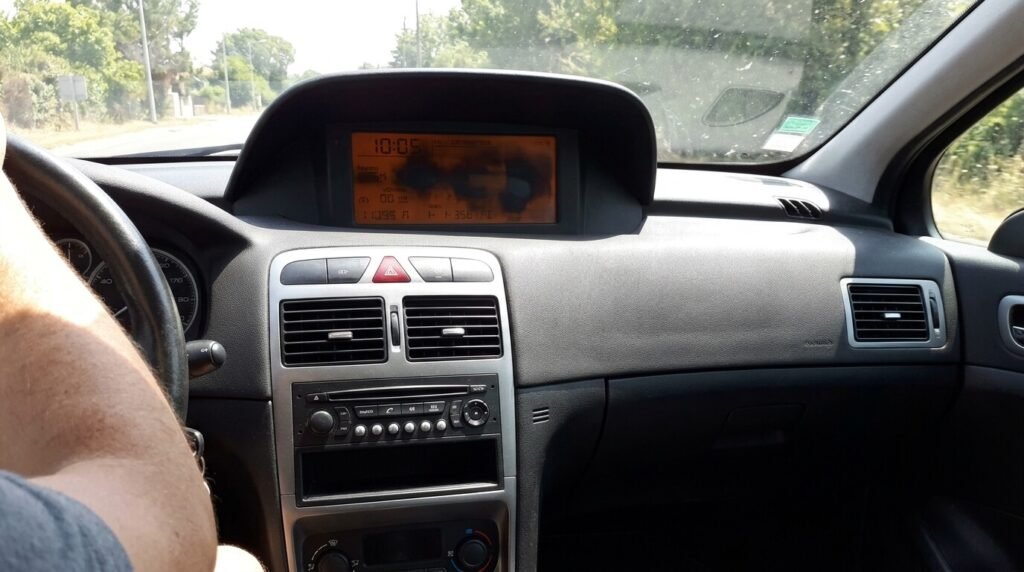 Écran d'ordinateur de bord d'une Peugeot 307 devenant noir et illisible sous le soleil.