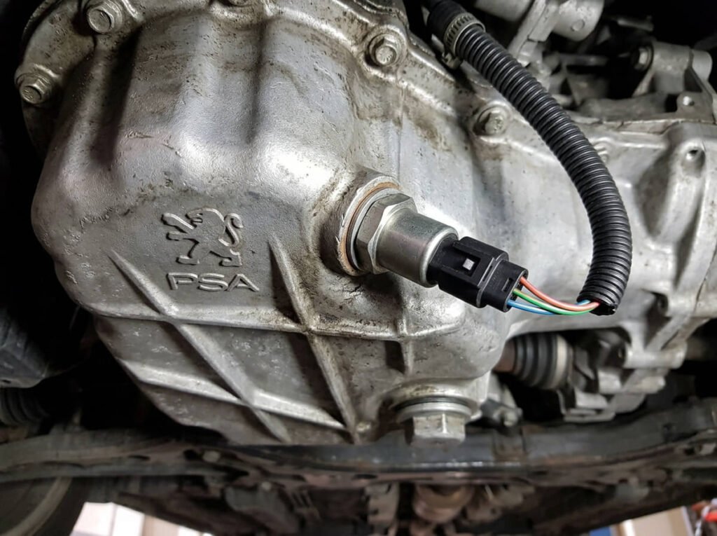 Sonde électrique de niveau et température d'huile vissée sur le carter moteur Peugeot.
