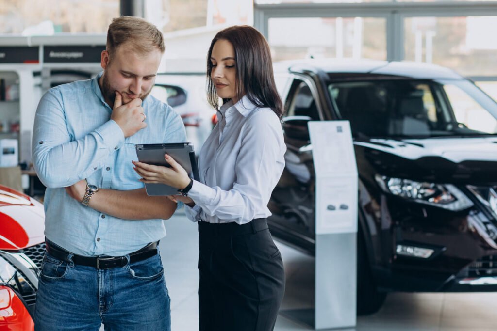 Client signant un contrat de location avec option d'achat pour une voiture électrique chez un concessionnaire.