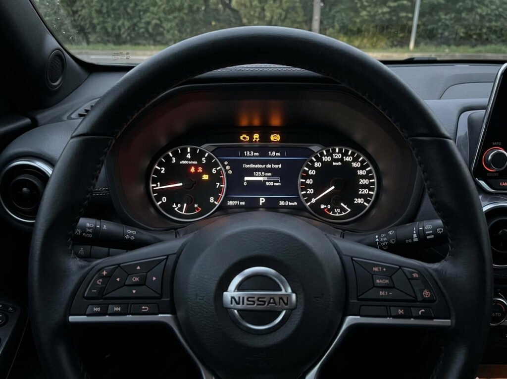 Tableau de bord d'un Nissan Juke avec les témoins moteur, ESP et ABS allumés simultanément.